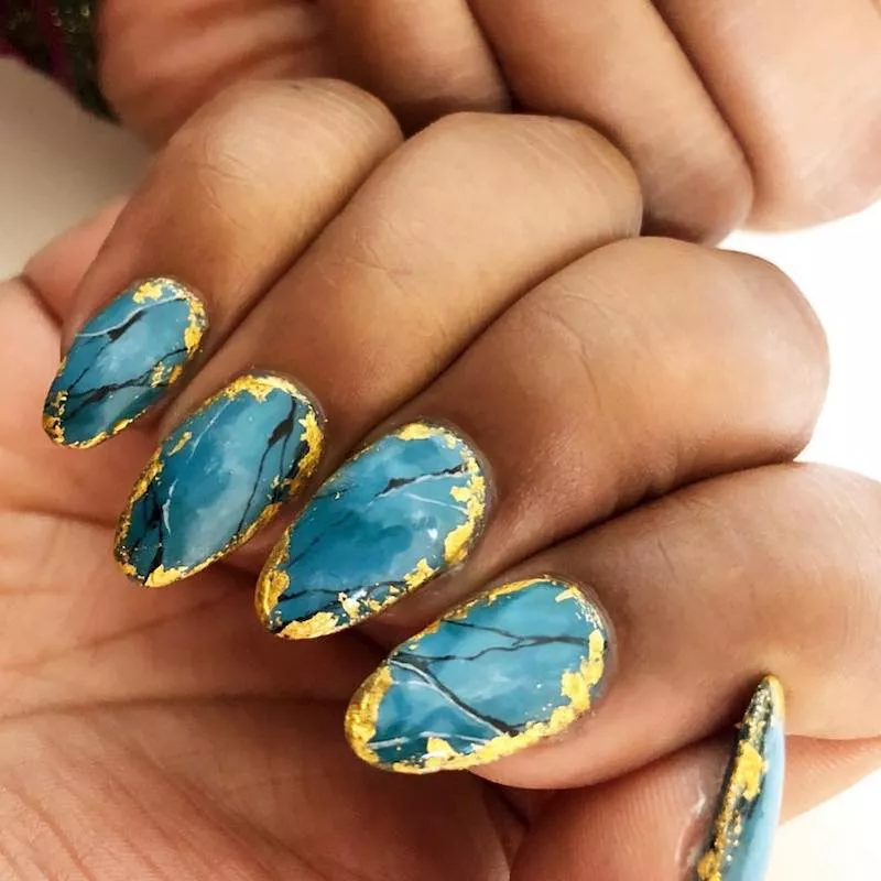 Almond-shaped nails with turquoise and gold design