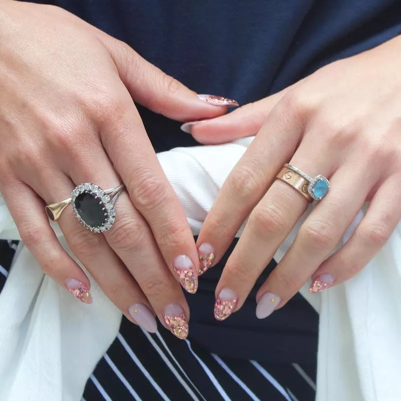 Almond-shaped nails with white and rose gold glitter design