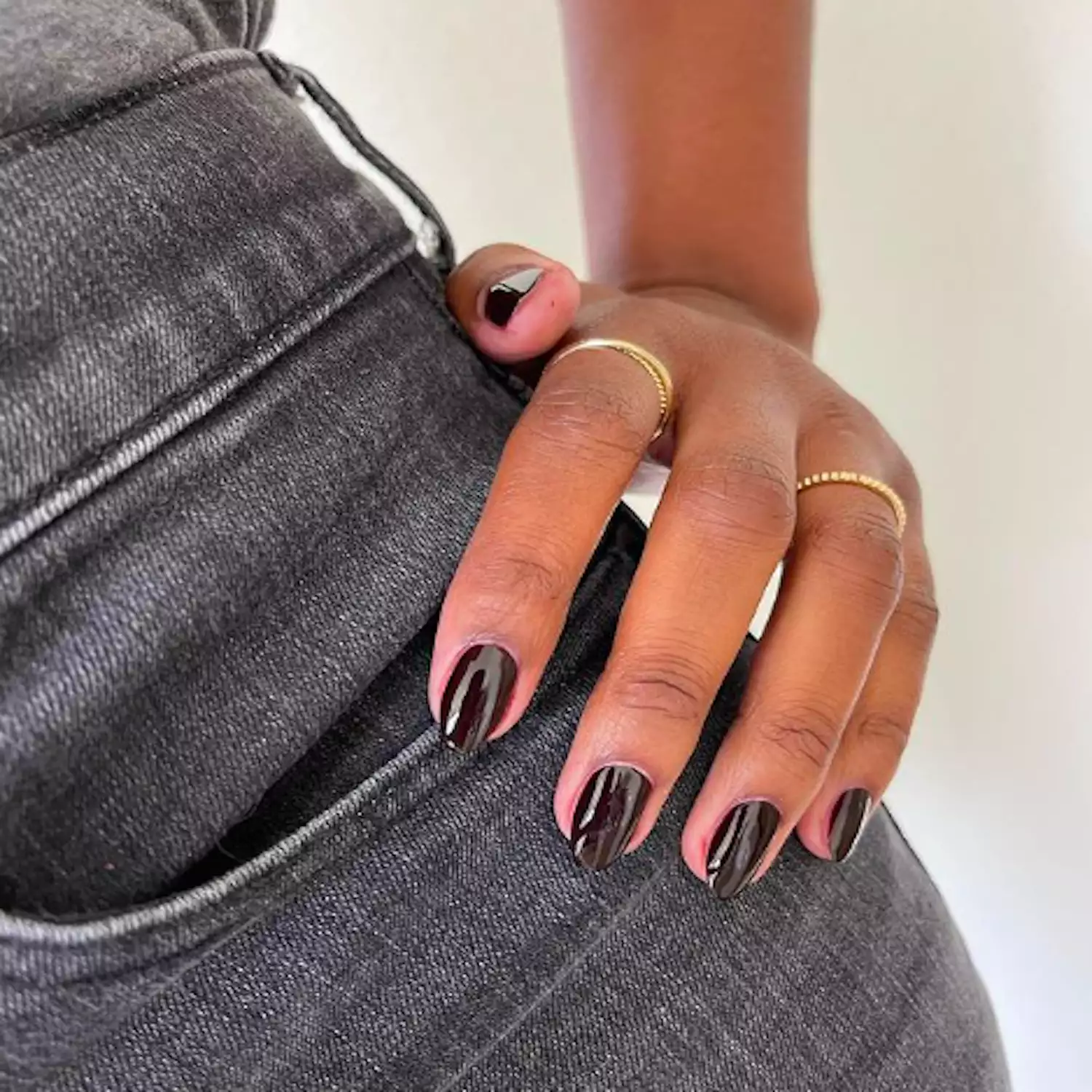 dark vampire-inspired nails posed on black denim jeans