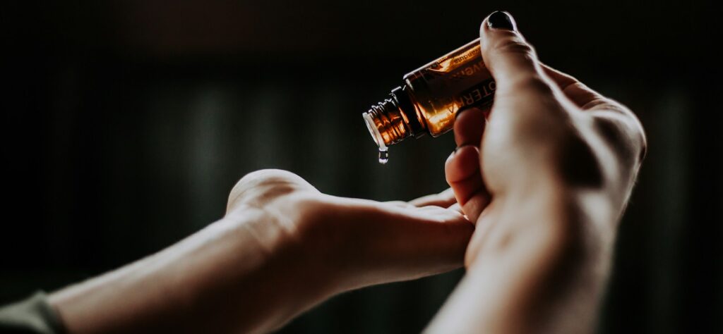 person holding amber glass bottle