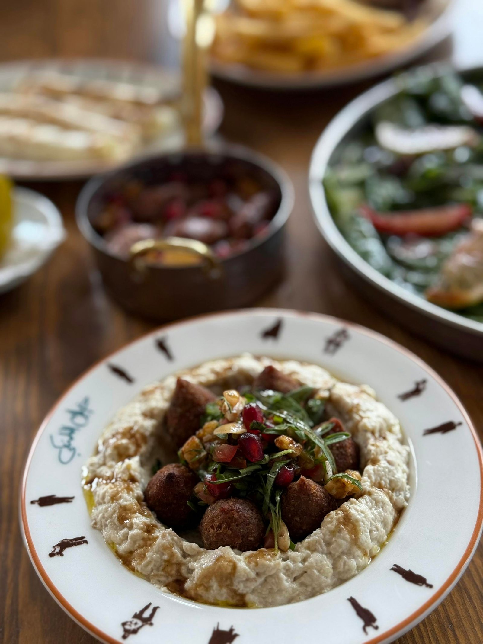 Close-up of a falafel bowl with hummus and toppings, perfect for Middle Eastern cuisine lovers.