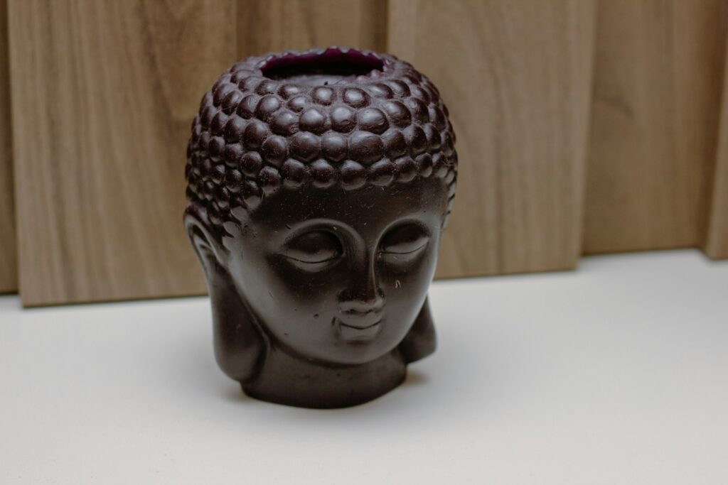 A ceramic buddha head sitting on top of a table