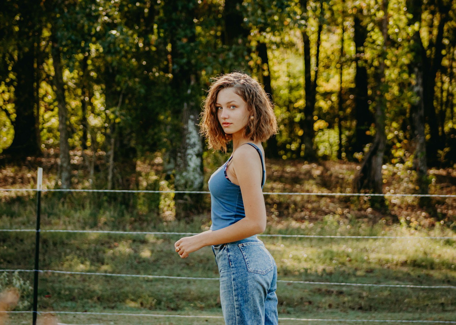 a woman standing in front of a fence