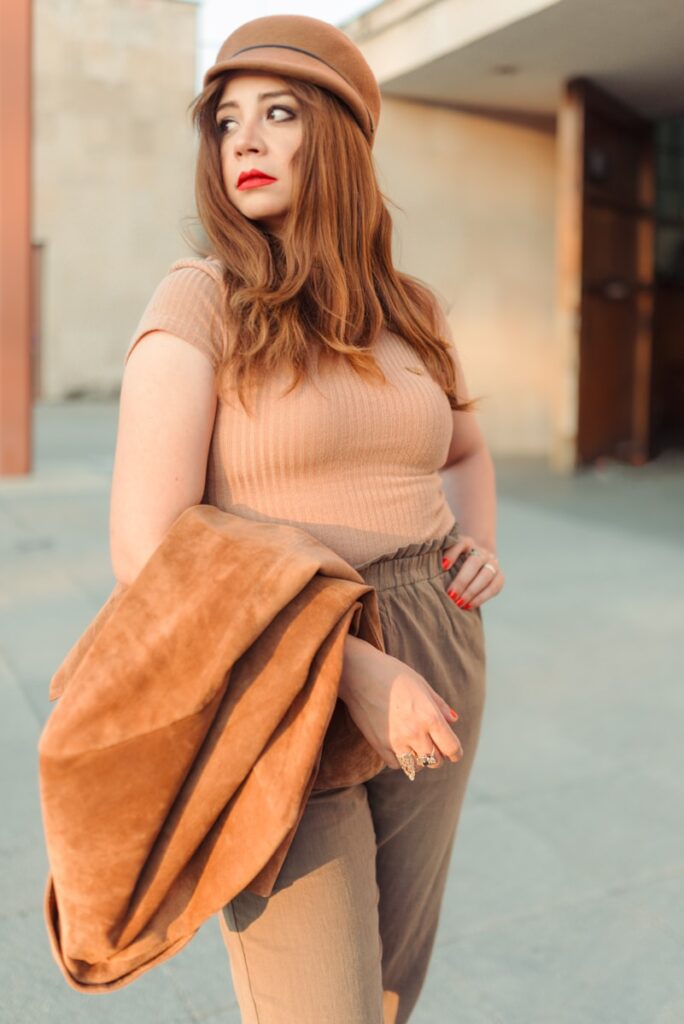 a woman in a tan top and brown pants