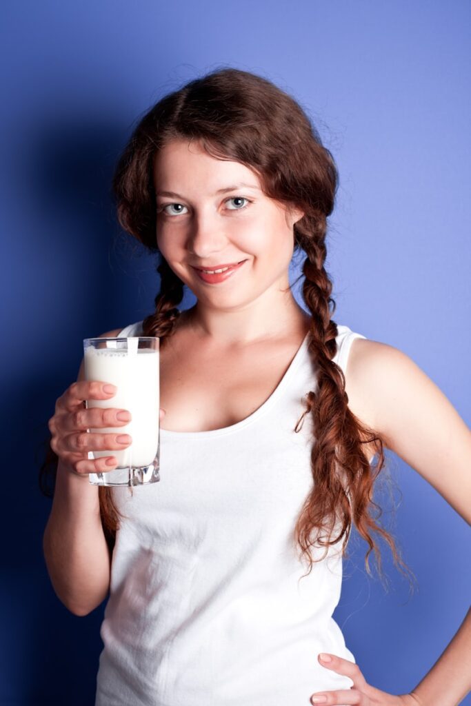 A young woman holding a glass of milk