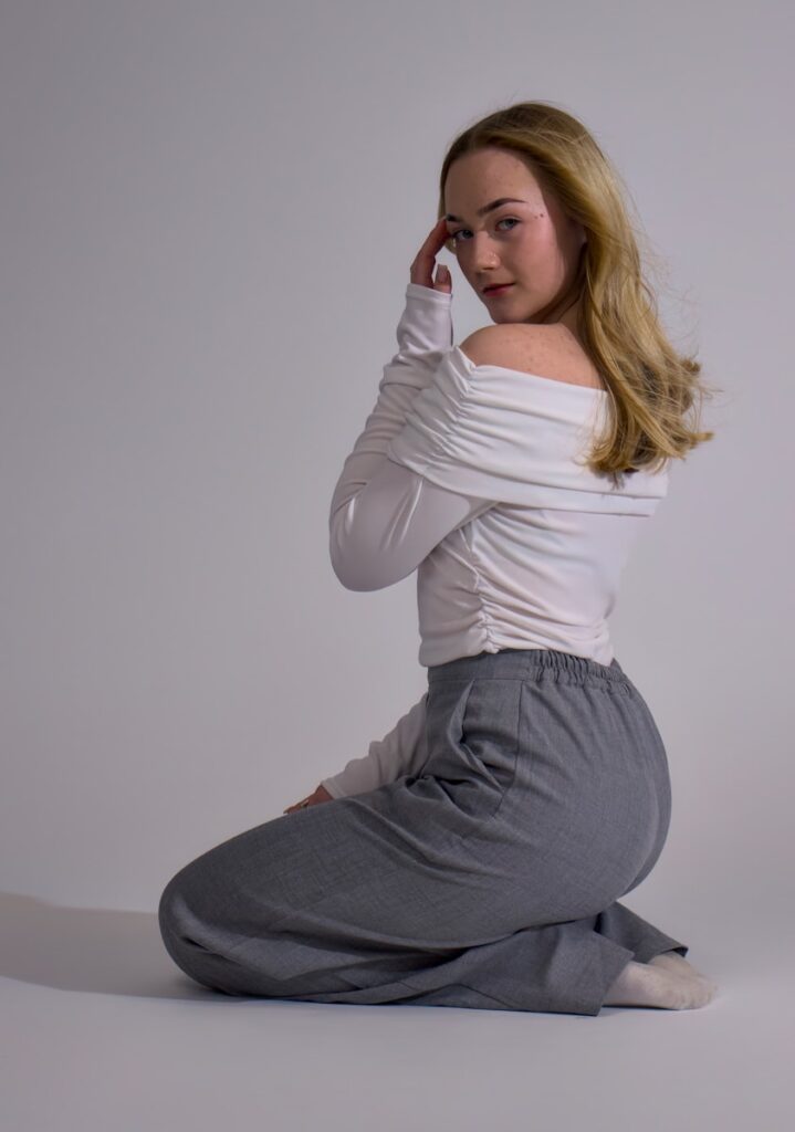 A woman sitting on the floor with her hands on her head