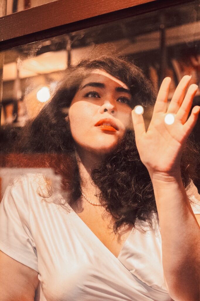 A woman in a white shirt is holding her hand up
