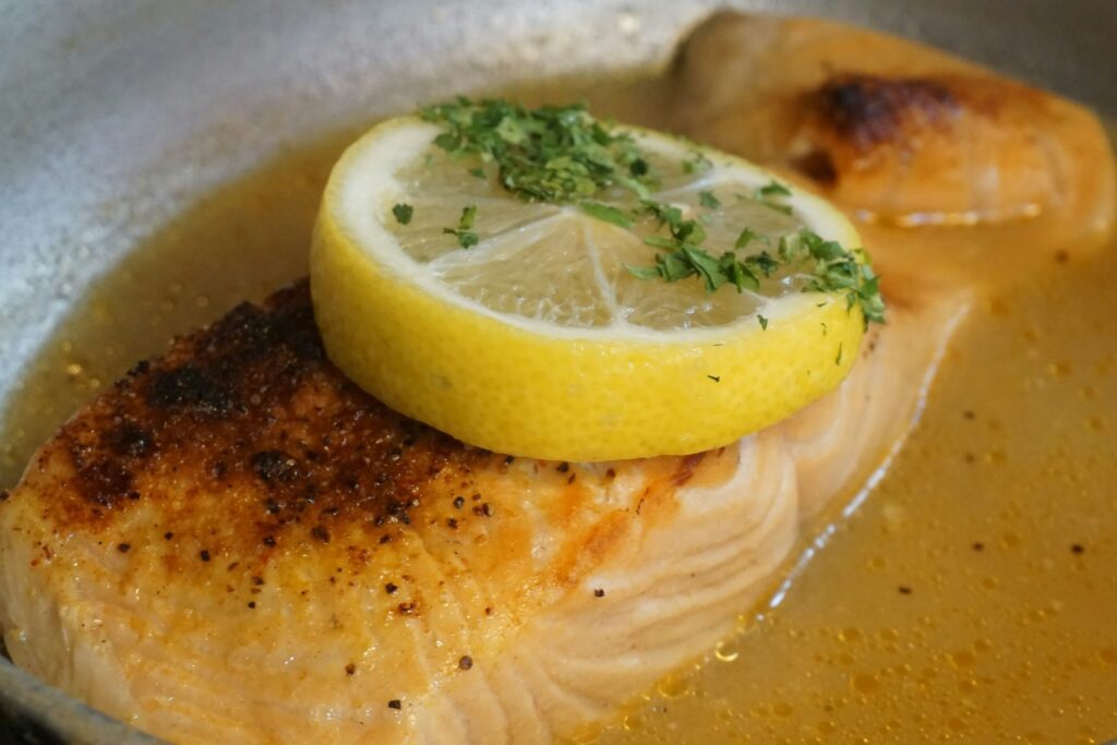 A piece of fish with a lemon slice on top of it