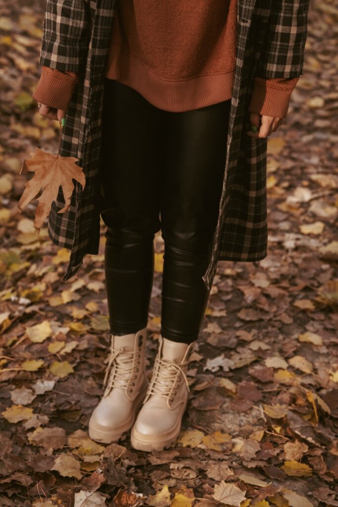 a woman standing in a leaf filled forest