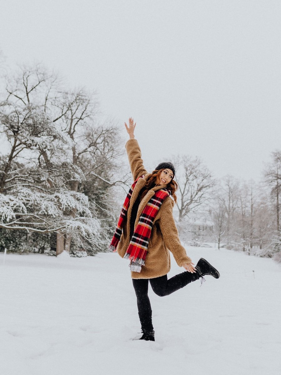 a woman standing in the snow with her arms in the air