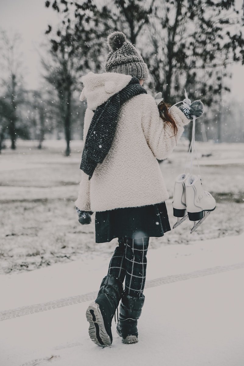 a woman walking down a snow covered street