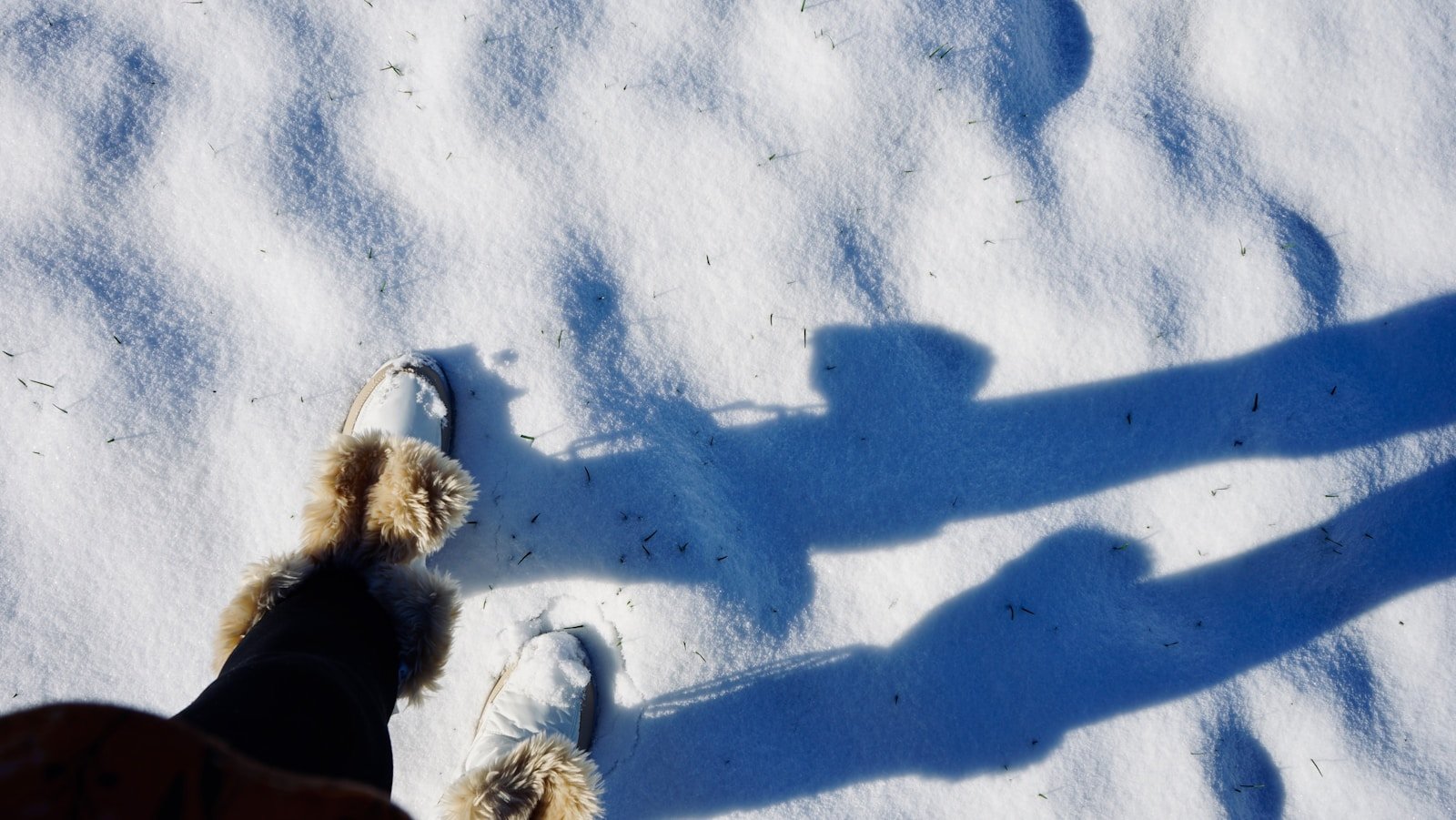Best Winter Boots to Style With Every Outfit a shadow of a person standing in the snow