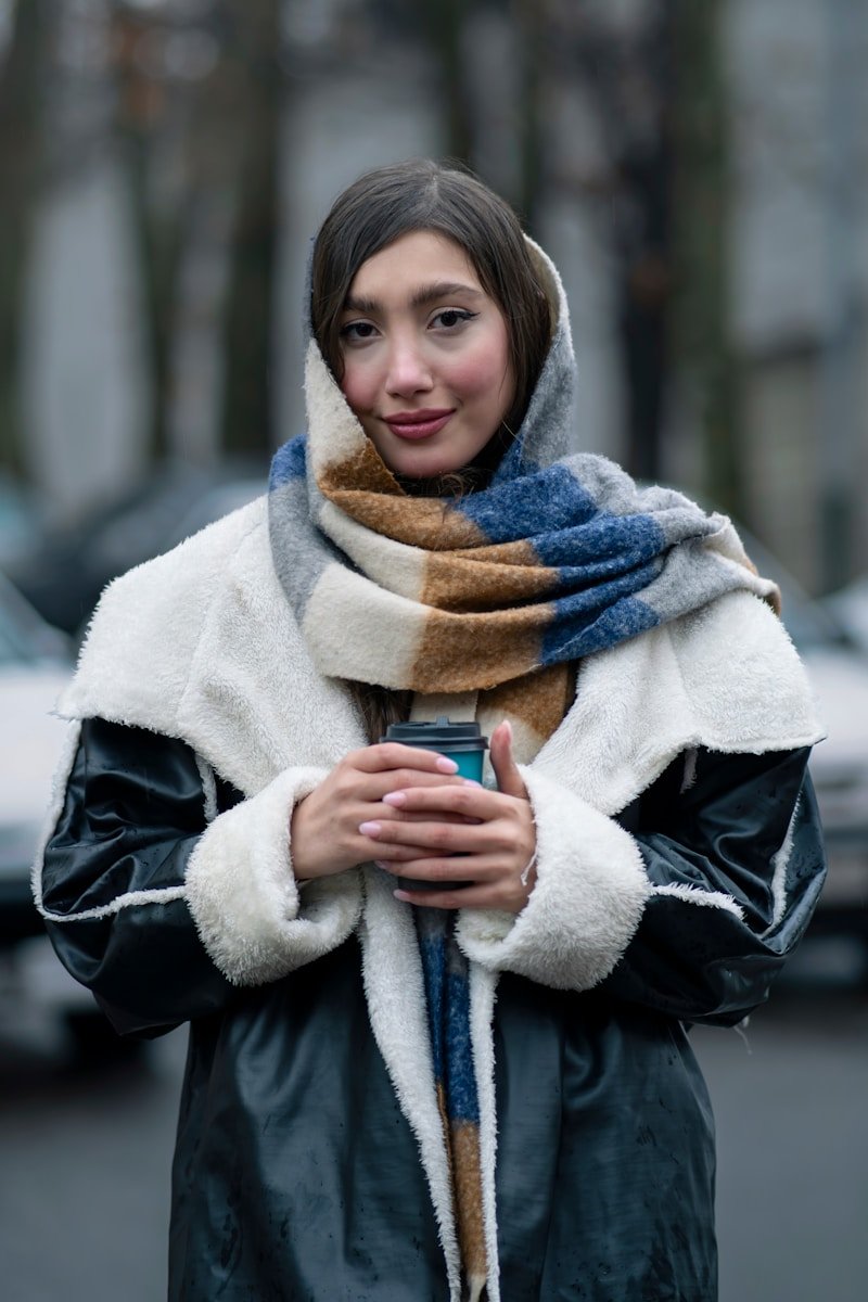 A woman standing on a street holding a cell phone