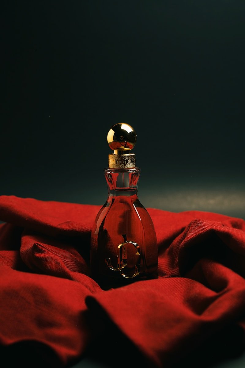 A bottle of perfume sitting on top of a red cloth