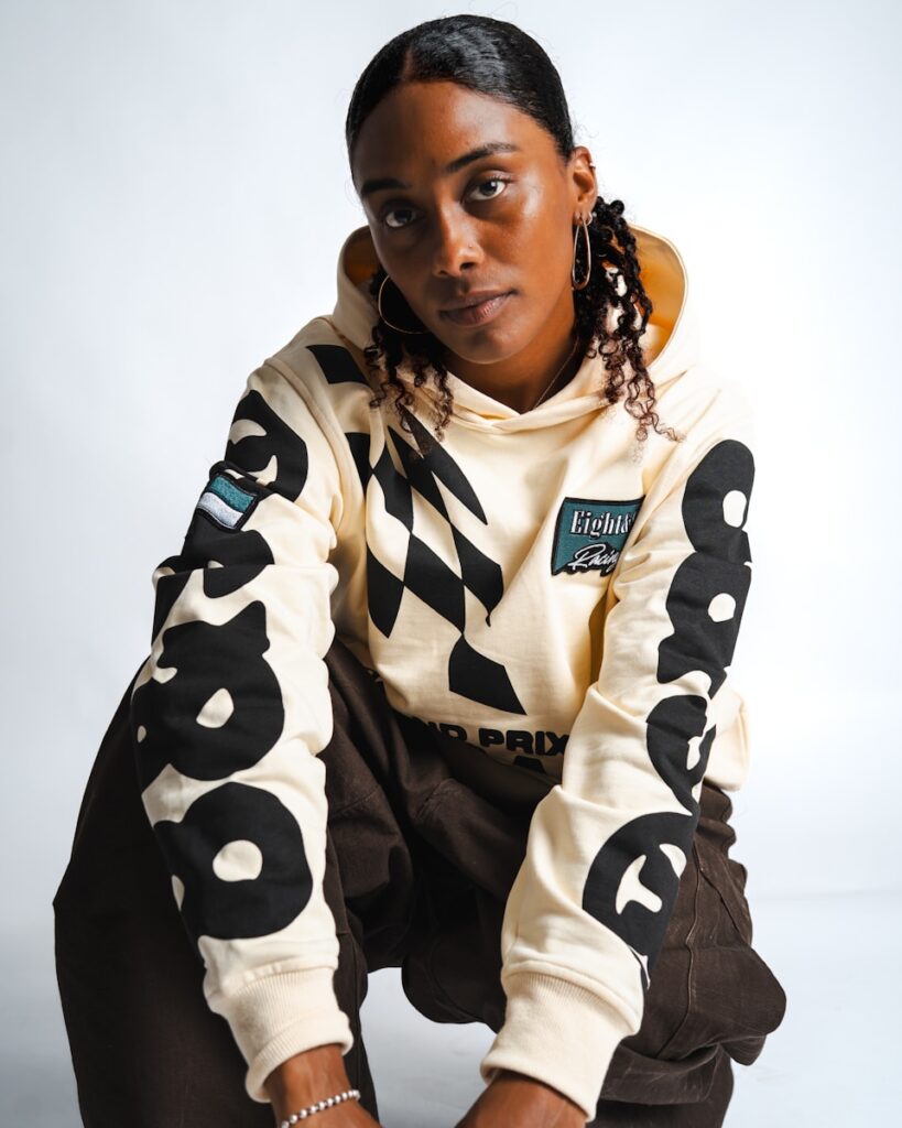 Woman in a cream hoodie with large black numbers.