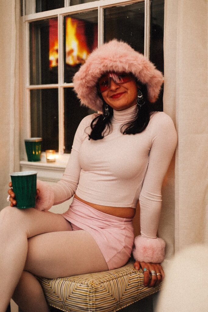 A woman sitting on a stool with a cup of coffee