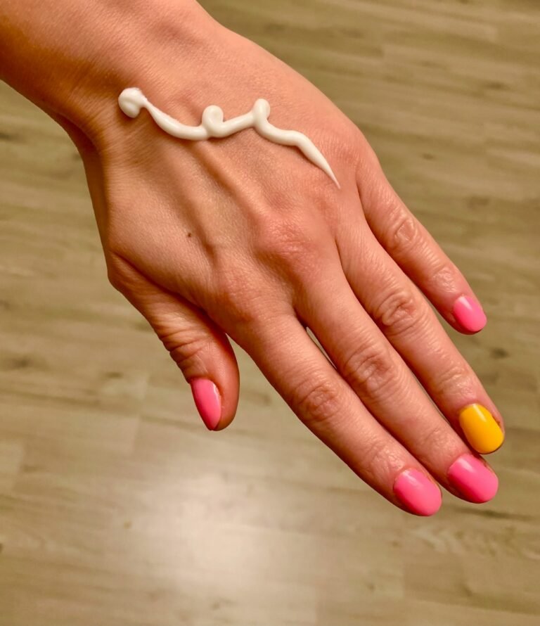 a woman's hand with a yellow and pink manicure