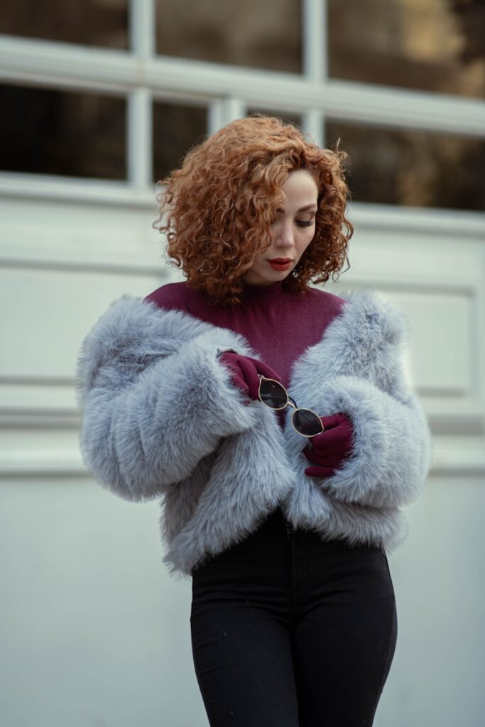 Woman with curly red hair wearing a fur coat