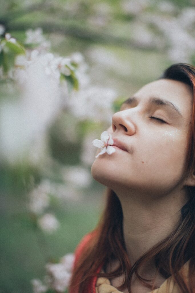 a woman with her eyes closed and a flower in her mouth