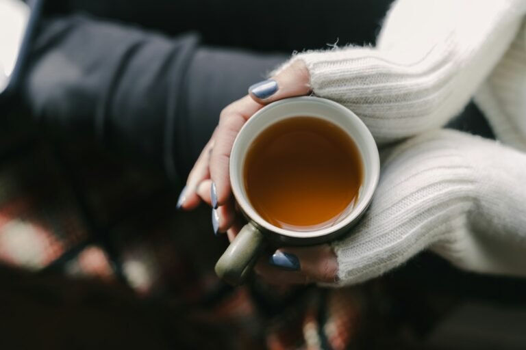 A woman holding a cup of tea in her hands