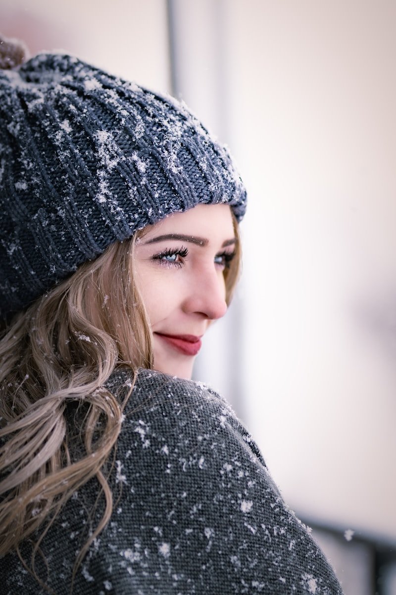 a woman wearing a gray sweater and a gray hat