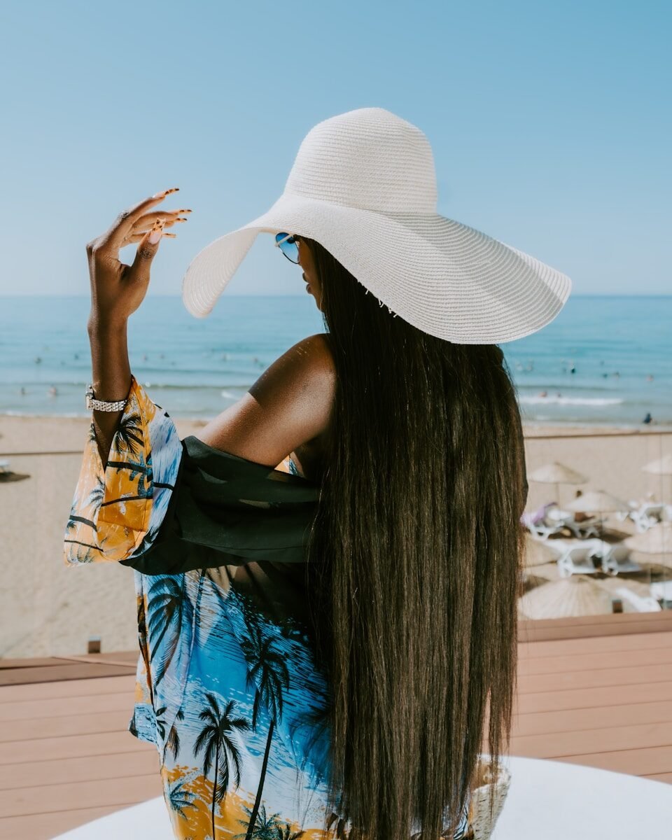 20 Classy Summer Outfit Ideas That Look Elegant and Expensive Woman in a wide-brimmed hat at the beach