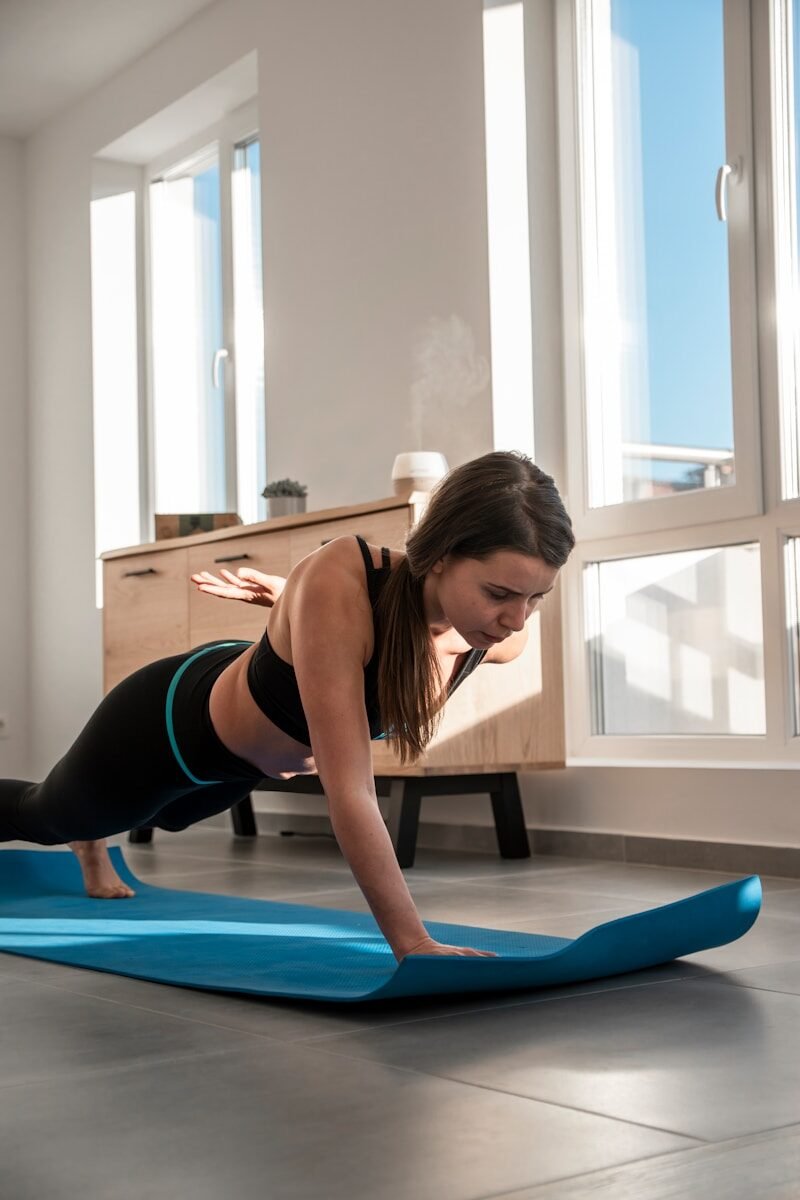a woman doing a plank exercise on a yoga mat