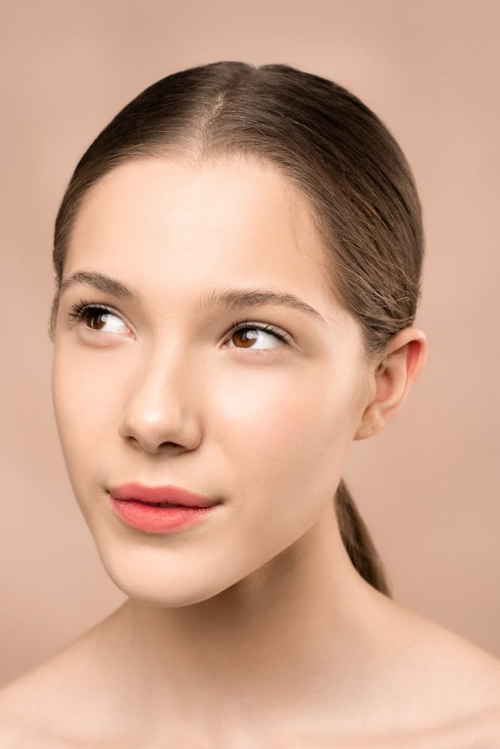 Mastering the First Impression: Your intriguing post title goes here Close-up portrait showcasing a young woman's flawless skin and elegant pose on a soft background.