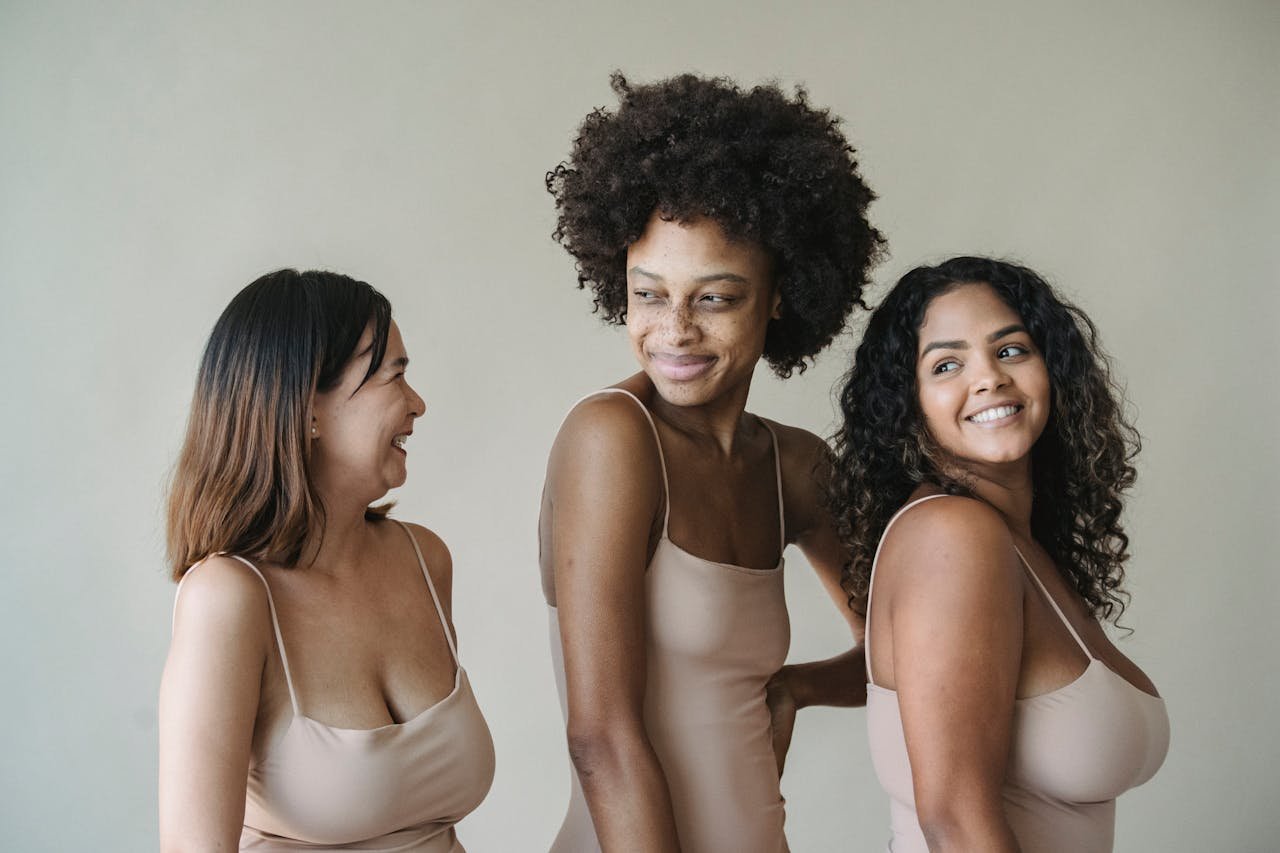 Celebrating body positivity and diversity with women posing confidently in neutral-toned fashion.