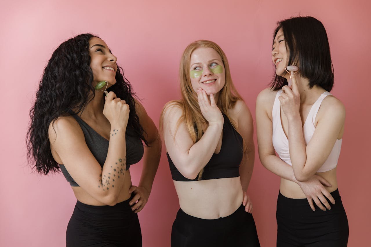 Crafting Captivating Headlines: Your awesome post title goes here Three diverse women using jade rollers and face masks, enjoying a skincare routine.